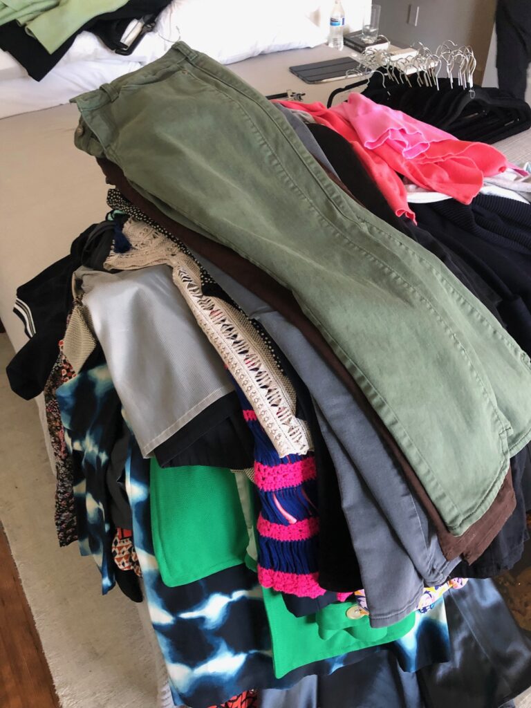 pile of clothes on bed to be dsicarded