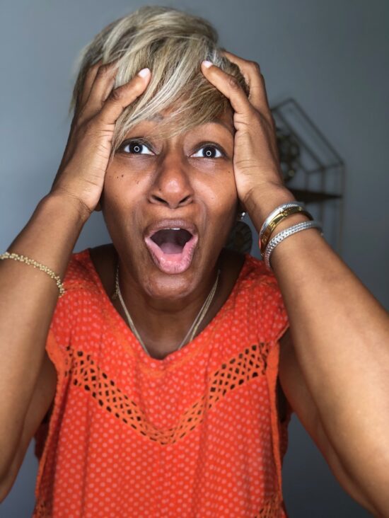 Black woman holding her head in agony